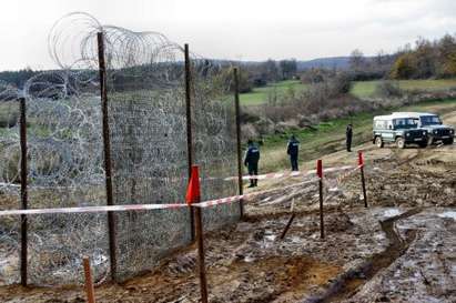 Оградата на границата срещу бежанците рухва, полицаи я подпират с колове и дървета